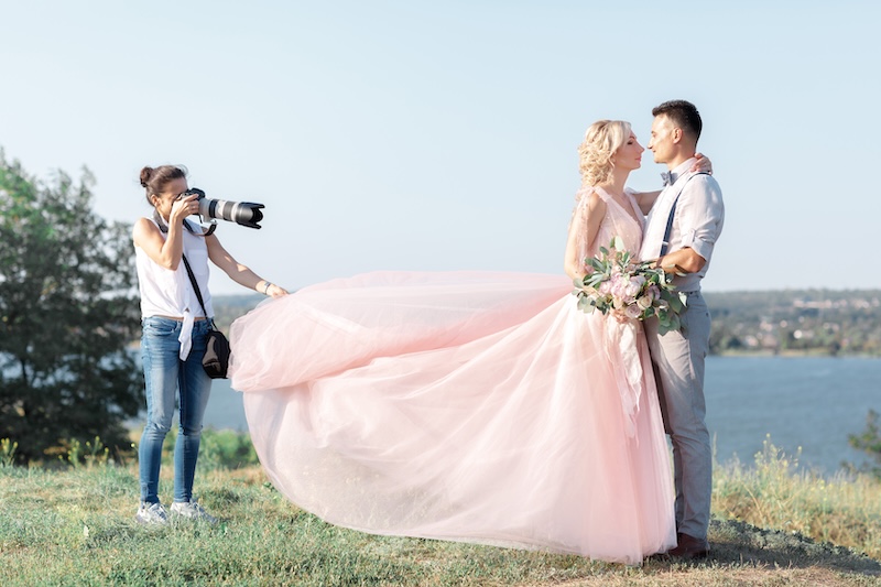 wedding photographer takes pictures of bride and groom in nature. wedding couple on photo shoot. photographer in action