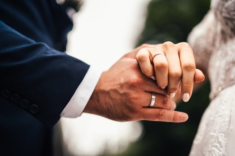 Holding wedding rings. Noble metal jewellery for married couples.Wedding ceremony and planing.Holding traditional bridal commitment jewellery.Golden ring for bride and groom.Marriage proposal exchange