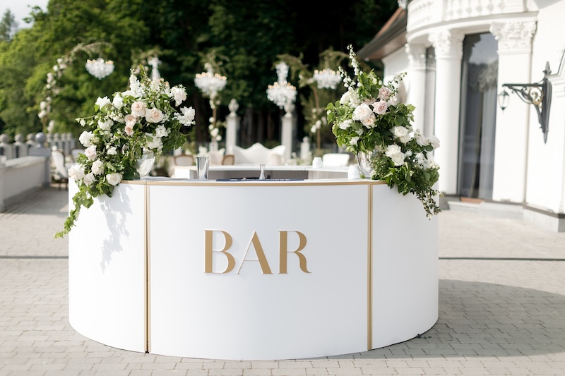Bar counter decorated with flowers at a wedding party.